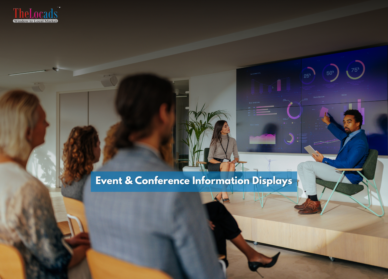 Conference room with attendees watching a presentation on a large digital display showing data visualizations and analytics.